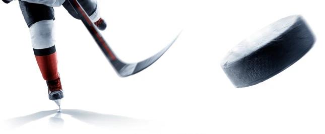Close-up of a hockey player releasing a shot, puck in flight
